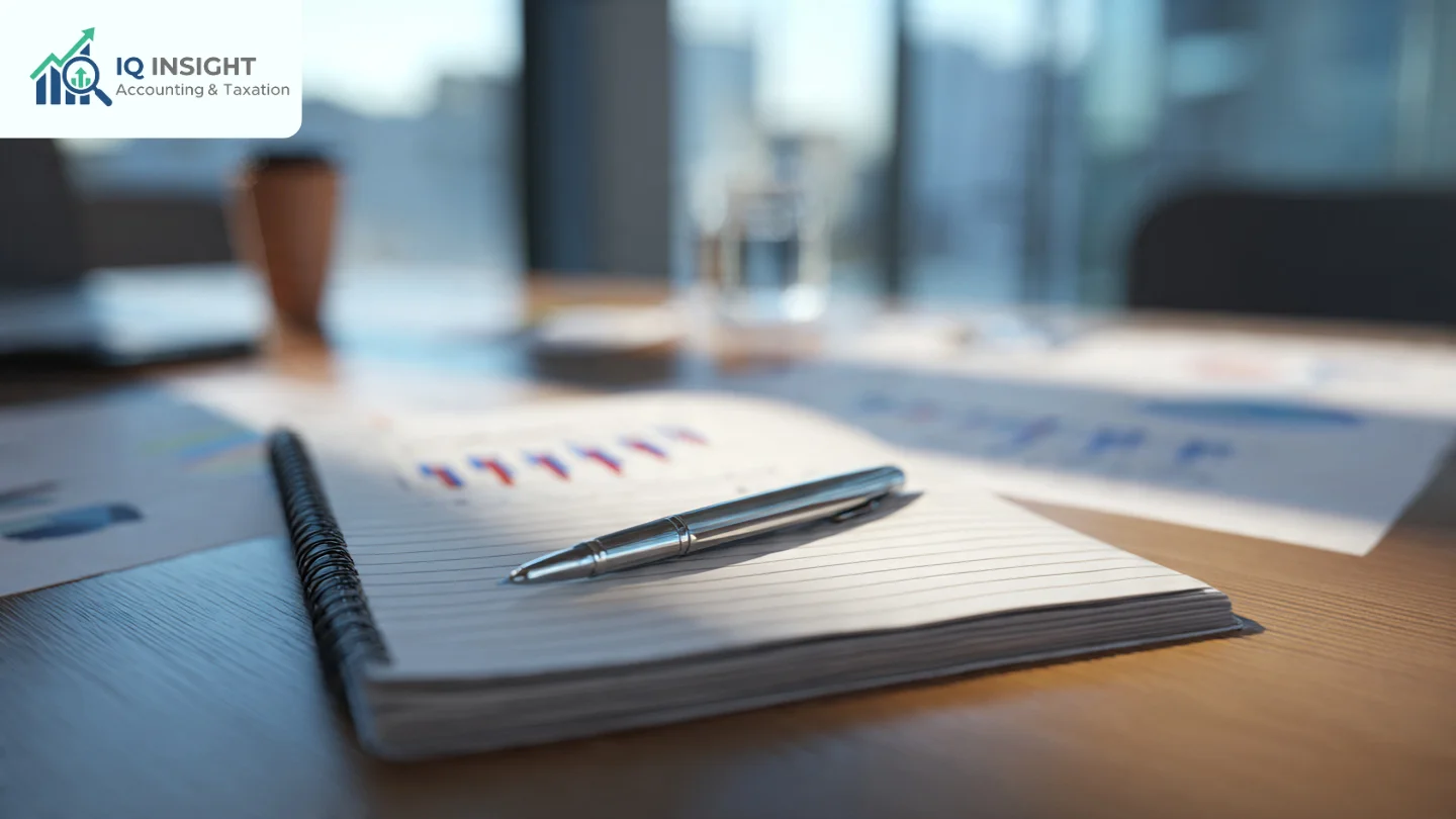 Close-up of a silver pen on a lined notebook with financial charts in the background.