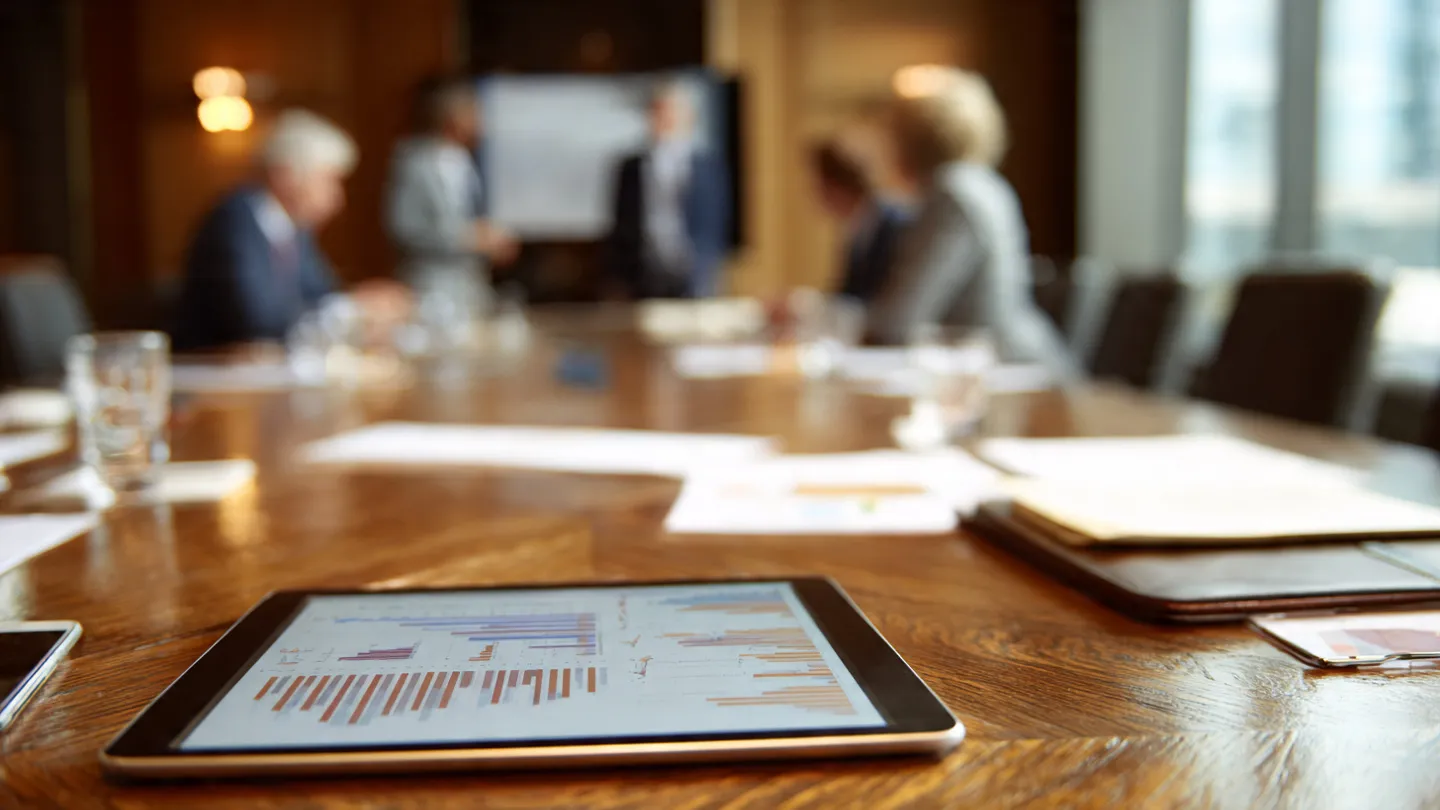 Tablet with financial growth charts used by a corporate team to approach tax planning meetings