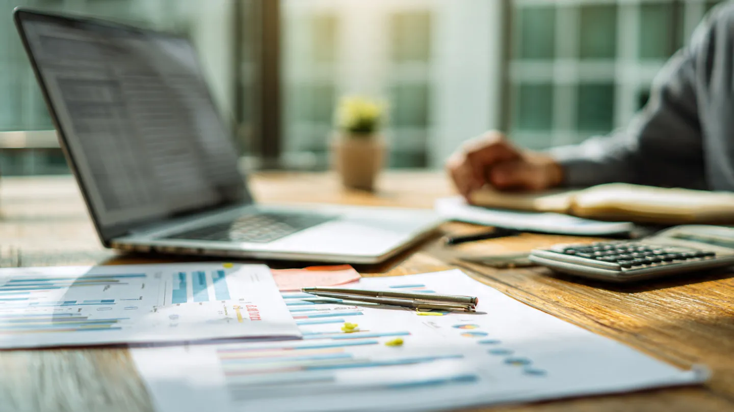 Close-up of financial charts and calculator highlighting potential minor reporting gaps.