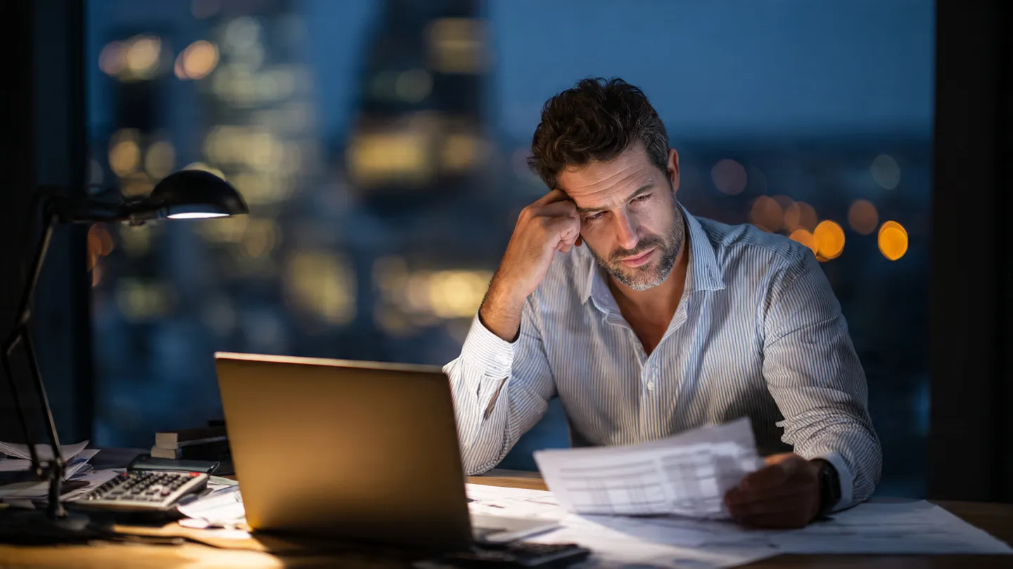 Business owner working late to resolve the Gulf struggle with accurate bookkeeping and finances.
