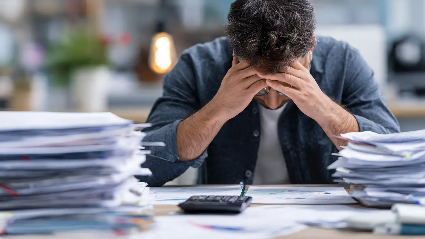 Stressed owner seeing how payroll errors impact business operations late at night in the UAE